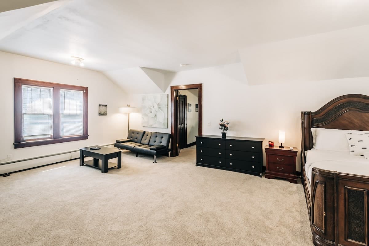 Primary bedroom with queen bed and warm wooden furniture